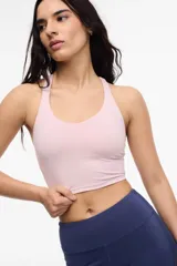 Top deportivo negro con escote en V, breteles finos cruzados en la espalda y copas removibles.