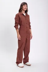 Enterito marrón de jean con cuello camisero, manga larga, cierre frontal con botones, bolsillos en el pecho y laterales.