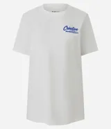 Remera de algodón color blanco tiza, manga corta y cuello redondo. Presenta un estampado grande en la espalda con la palabra "Creative" en tipografía cursiva iridiscente, un oso de goma con efecto holográfico en tonos azules y rosados, y el texto "MATTERS MORE THAN P¡FORMACE" debajo.