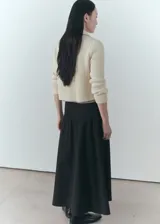 Chaqueta color crema de tejido de punto de canalé, con cuello camisero, cierre de botones en la parte delantera y manga larga.
