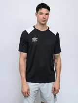 Remera deportiva Umbro de manga corta, color negro con hombros y cuello en blanco. Presenta un cuello redondo con un detalle en V invertida en el centro.