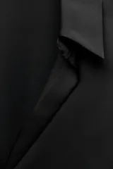 Camisa azul marino de satén con cuello solapa, escote en pico y mangas largas con puños abotonados.