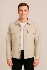 Sobrecamisa color beige con cuello clásico, cierre frontal con botones a tono, mangas largas con puños abotonados, dos bolsillos de parche en el pecho y corte recto.