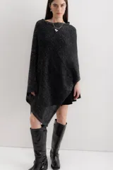 Poncho negro con detalles en gris, de tejido de punto grueso y corte asimétrico.