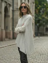 Poncho tejido de punto grueso, color mostaza/mostaza oscuro, con cuello redondo y caída amplia.