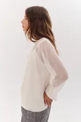 Sweater de punto calado color camel, con escote en V y mangas largas.