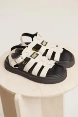 Sandalias de cuero sintético color lila con plataforma negra y tiras anchas cruzadas.