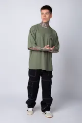 Remera color ladrillo de corte oversize, con cuello redondo y mangas cortas. Estampado pequeño en el pecho con un diseño circular en blanco y negro.