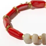 Pulsera elástica con cuentas tubulares rojas y doradas, y cuentas de piedra irregulares color crema.