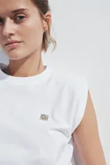 Camiseta blanca de algodón con cuello redondo y manga sisa con hombreras. Detalle de aplicación metálica ZA en el delantero.