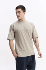 Remera lisa color beige de corte oversize, con escote redondo y mangas cortas.