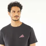 Camiseta gris oscuro de manga corta con estampado en la espalda del logo de la lengua de los Rolling Stones con diseño de palmeras en tonos turquesa y rosa.