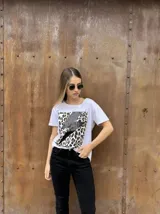Remera blanca de algodón con estampado de leopardo y rayo negro con lentejuelas.