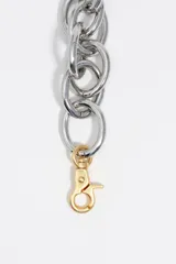 Collar maxi de cadena con eslabones circulares gruesos y acabado mate dorado. Cuenta con un cierre de mosquetón metálico en contraste plateado.