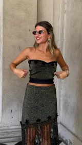 Top strapless tejido con hilo lurex negro y dorado, con escote corazón y detalles de apliques de crochet negros en el borde superior.