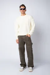 Pantalón cargo negro de corte relaxed fit y tiro medio, con múltiples bolsillos y costuras a contraste en color blanco.