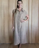 Túnica color beige de corte recto, con cuello camisero, manga corta, botones frontales y tajos laterales.