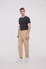 Pantalón de gabardina color verde oliva oscuro, de corte recto, con bolsillos laterales y traseros. Se ajusta a la cintura con cordón.