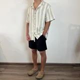 Bermuda negra de lino con corte arriba de la rodilla y cordón ajustable en la cintura.