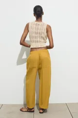 Pantalón color verde oliva de tiro alto, corte ancho y largo 7/8. Tiene cintura elástica ajustable con cordón, bolsillos de plastrón en delantero y espalda.