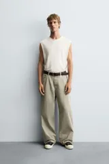 Pantalón de jean blanco, corte holgado y amplio en toda la pierna, tiro medio, tejido ligero, cinco bolsillos, efecto lavado y cierre frontal con cremallera y botón.