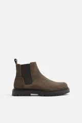 Bota Chelsea color marrón topo de cuero serraje, con elásticos laterales negros, tirador trasero y suela track.