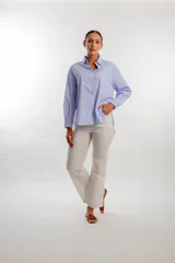 Camisa de corte clásico color celeste, con botones frontales y mangas largas.