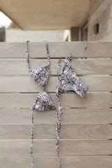 Conjunto de bikini azul con corpiño de triángulos movibles con almohadillas desmontables, que se ata al cuello y a la espalda. La bombacha es vedetina con tiritas a los costados para atar a medida de la cadera.