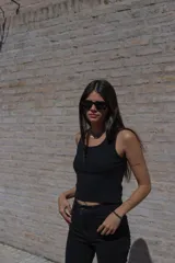 Musculosa negra ajustada al cuerpo con breteles finos y detalle de bordado en el frente.