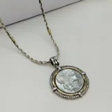 Conjunto de plata 925, oro y nácar con circonias. Incluye cadena de 45cm y dije redondo de 35mm con la figura de San Jorge.