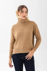 Polera negra de cuello alto y corte holgado, con cinturón fino de cuero negro con hebilla dorada.