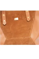 Bolso grande color camel con paneles de gamuza natural suave al centro y 100 % cuero en los laterales. Presenta dos asas de mano con detalles estampados.