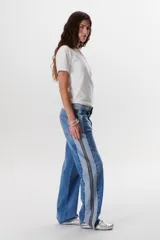 Pantalón de jean azul con paneles en distintos tonos de azul y marrón, corte recto y terminación desflecada.