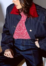 Sweater de tejido de punto color rojo con textura jaspeada, de corte recto y cuello redondo.
