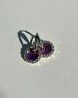 Par de aros colgantes con argolla de acero quirúrgico, dije circular de resina negra y borde de strass plateado.