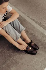 Zueco de cuero color crudo con detalle de flecos y pieza central en cuero snake.