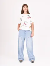 Remera blanca de corte recto con estampado de flores rojas y texto azul "PROFUMO DI FIORI".