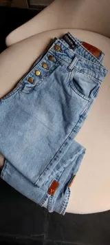 Pantalón de jean celeste de tiro alto, corte recto y etiqueta de cuero marrón en la parte trasera.