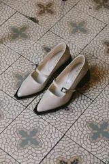 Mocasines color visón de charol con punta cuadrada y tira sobre el empeine.