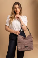 Bolso tipo shopper color beige con diseño acolchado geométrico y correa de hombro negra.