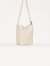 Cartera tipo tote confeccionada en cuero vacuno color crudo, con textura tipo piel de cocodrilo. Tiene correa larga al hombro y apliques metálicos con el logo de la marca. Incluye sobre interno desmontable con cierre.