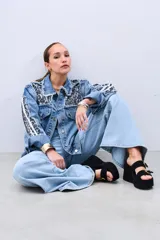 Campera de jean celeste con estampado animal print en cuello y solapas, y tres tiras blancas en las mangas.