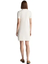 Vestido corto tipo chomba de Tommy Hilfiger, color blanco, de corte slim, con cuello polo, cartera de botones y logo bordado en el pecho.