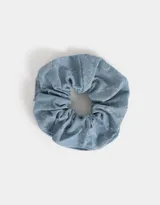 Gomita de pelo tipo scrunchie de tela denim celeste con diseño de flores grabadas con láser.