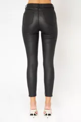 Pantalón jean engomado negro, de corte skinny y tiro medio.