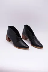 Botines negros de cuero con corte en V en el empeine y taco cuadrado de madera.