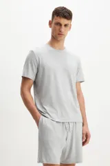 Conjunto de pijama gris claro melange, compuesto por una remera de manga corta con cuello redondo y un short con cintura elástica ajustable con cordón y bolsillos laterales.