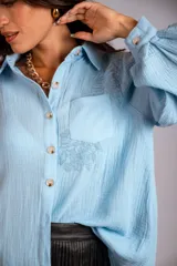 Camisa color beige de muselina con bordado en la parte delantera y manga globo con puño.