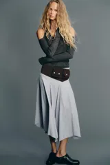 Falda midi de tiro medio con estampado de rayas verticales azules y blancas. Presenta costura de cintura asimétrica, detalle de pliegues y cierre lateral con cremallera oculta.