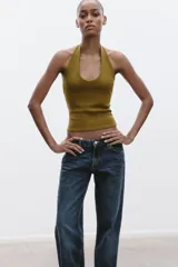 Top color crema con cuello halter y escote redondo. Espalda descubierta.